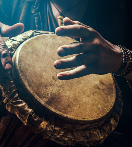 A man playing an ethnic percussion musical instrument jembe drummer