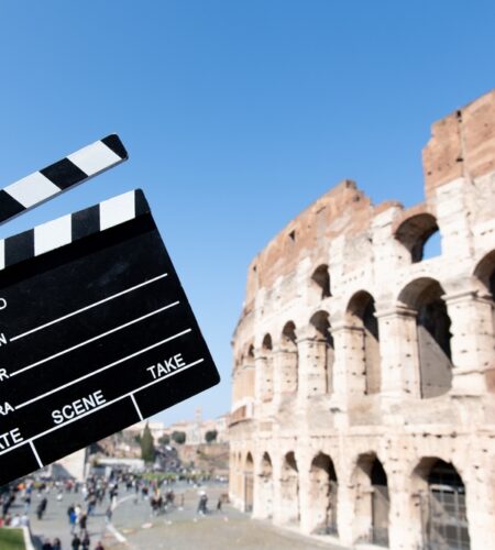 Movie clapper board in front of coliseum monument