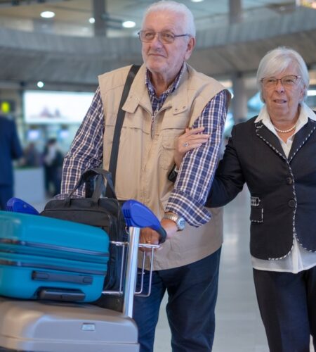 Senior couple travelers with trolley